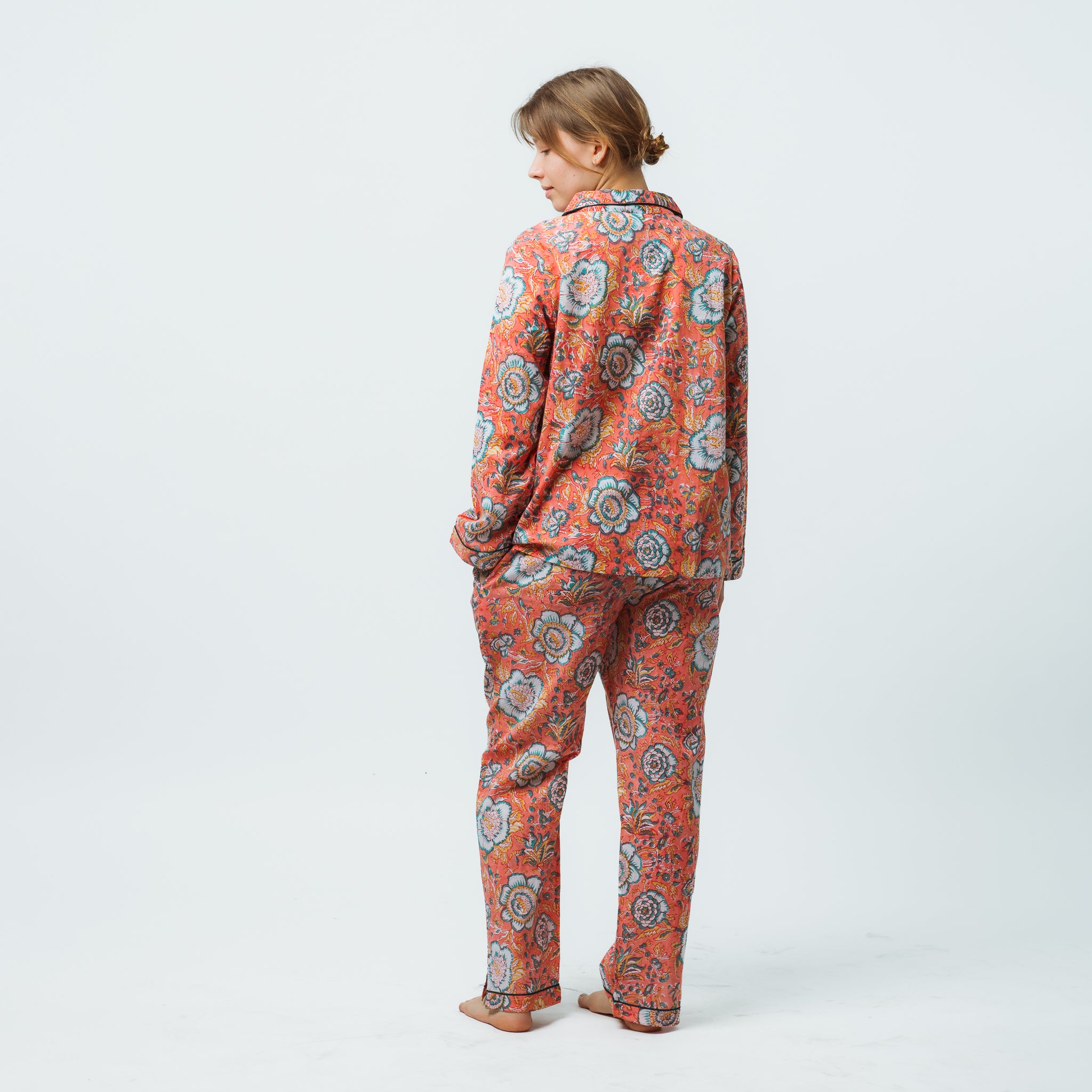 Person wearing a floral patterned onesie on a white background