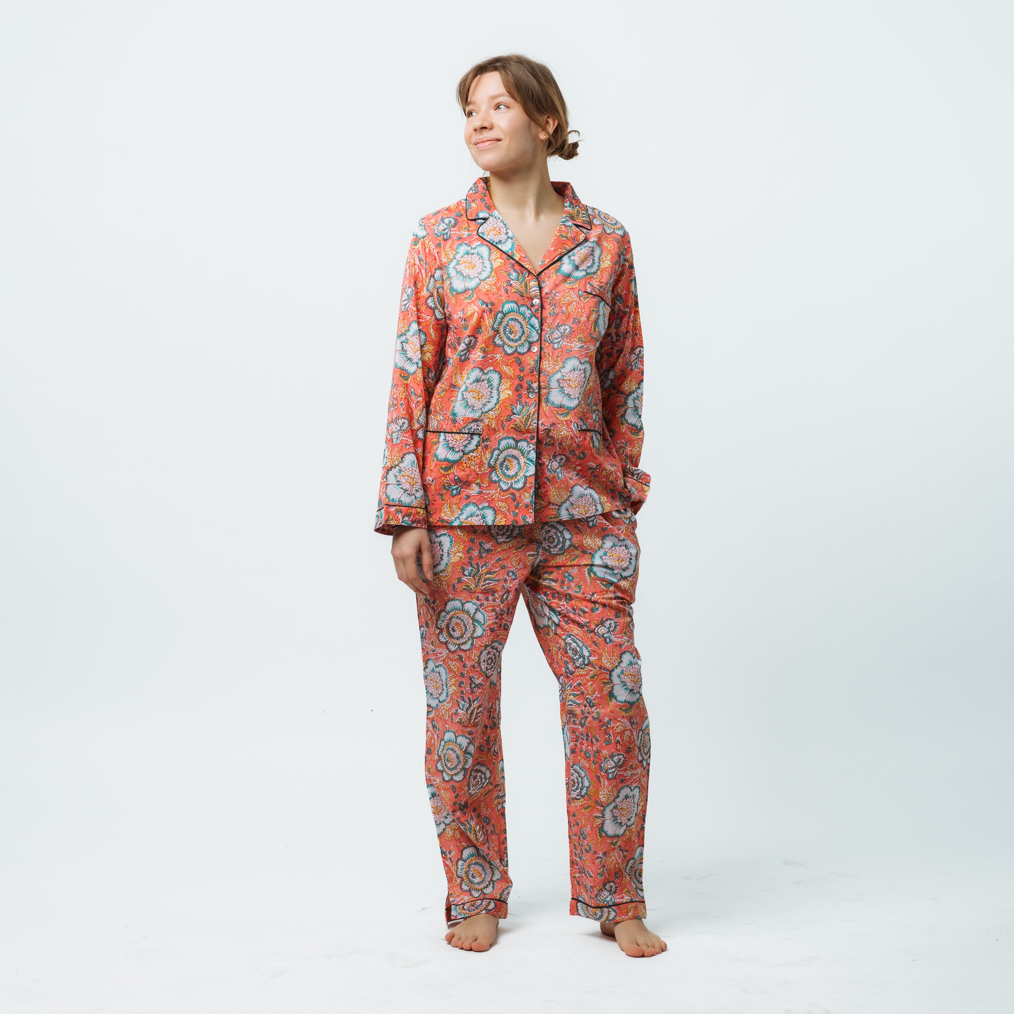 Person wearing a patterned pajama set on a white background