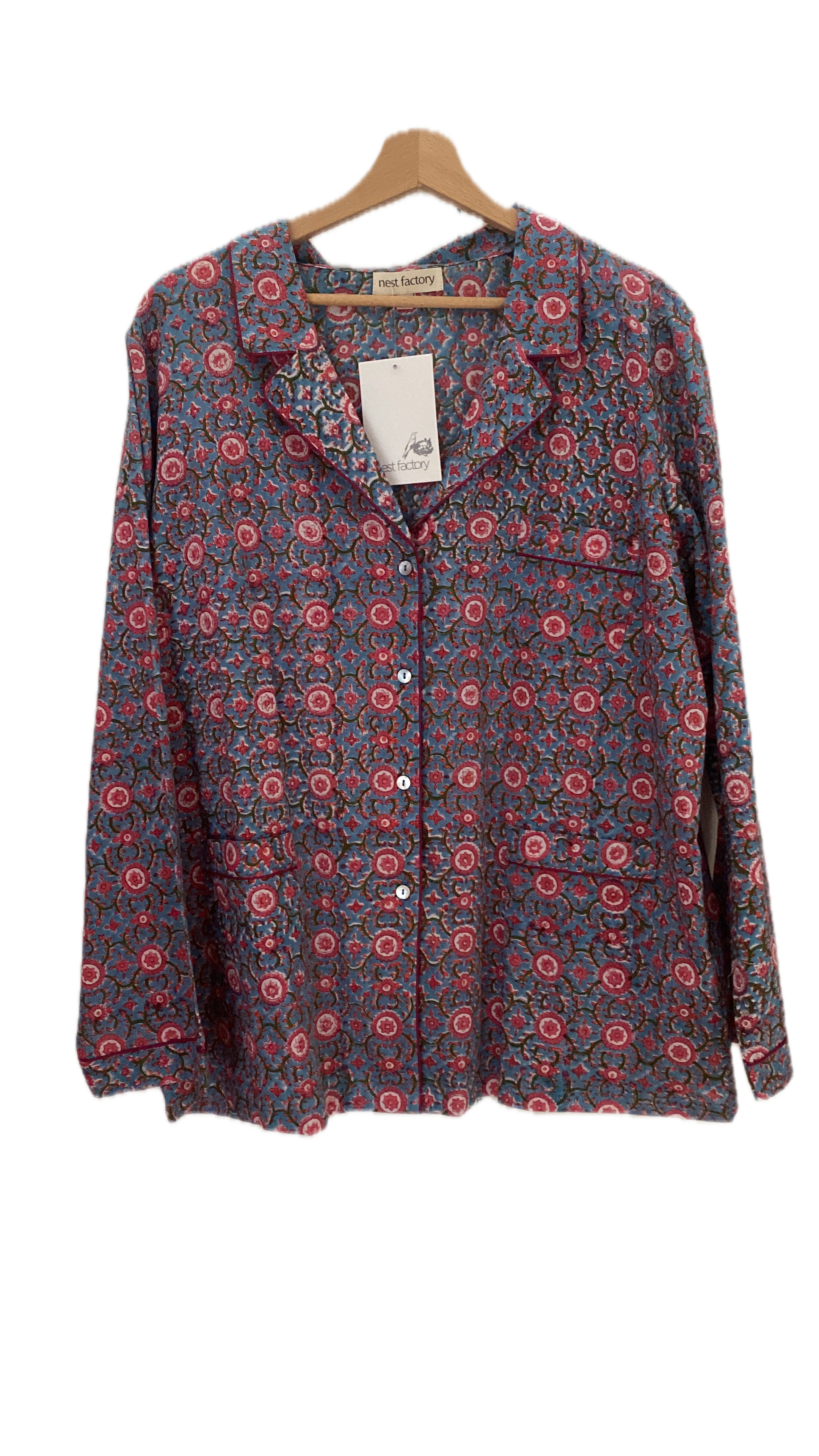 Floral patterned shirt on a hanger with a white background