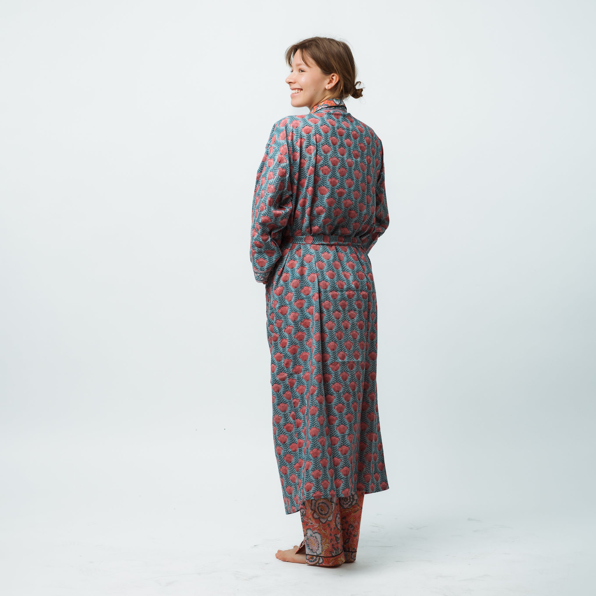 Woman wearing a long, patterned dress on a white background
