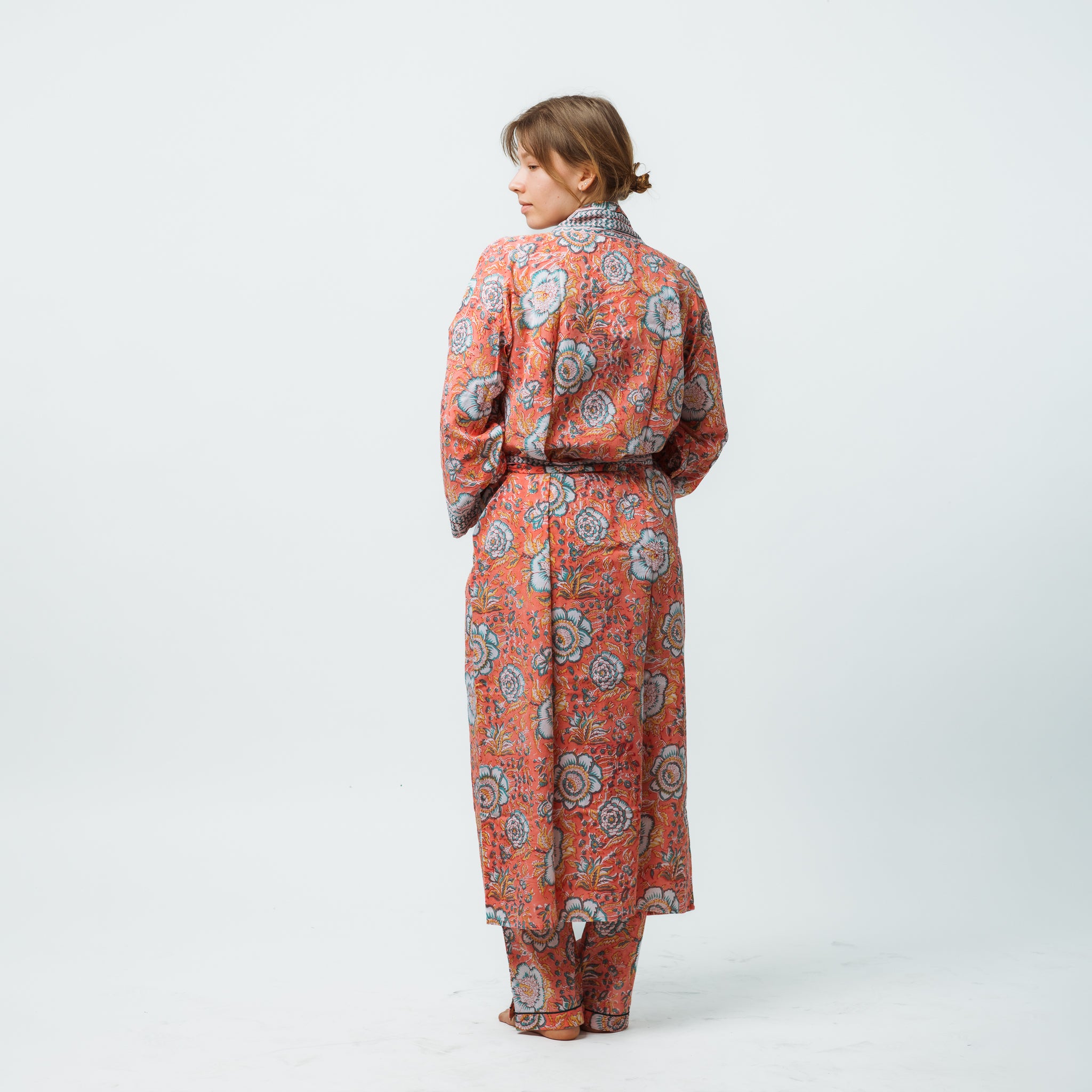 Woman wearing a floral patterned outfit on a white background
