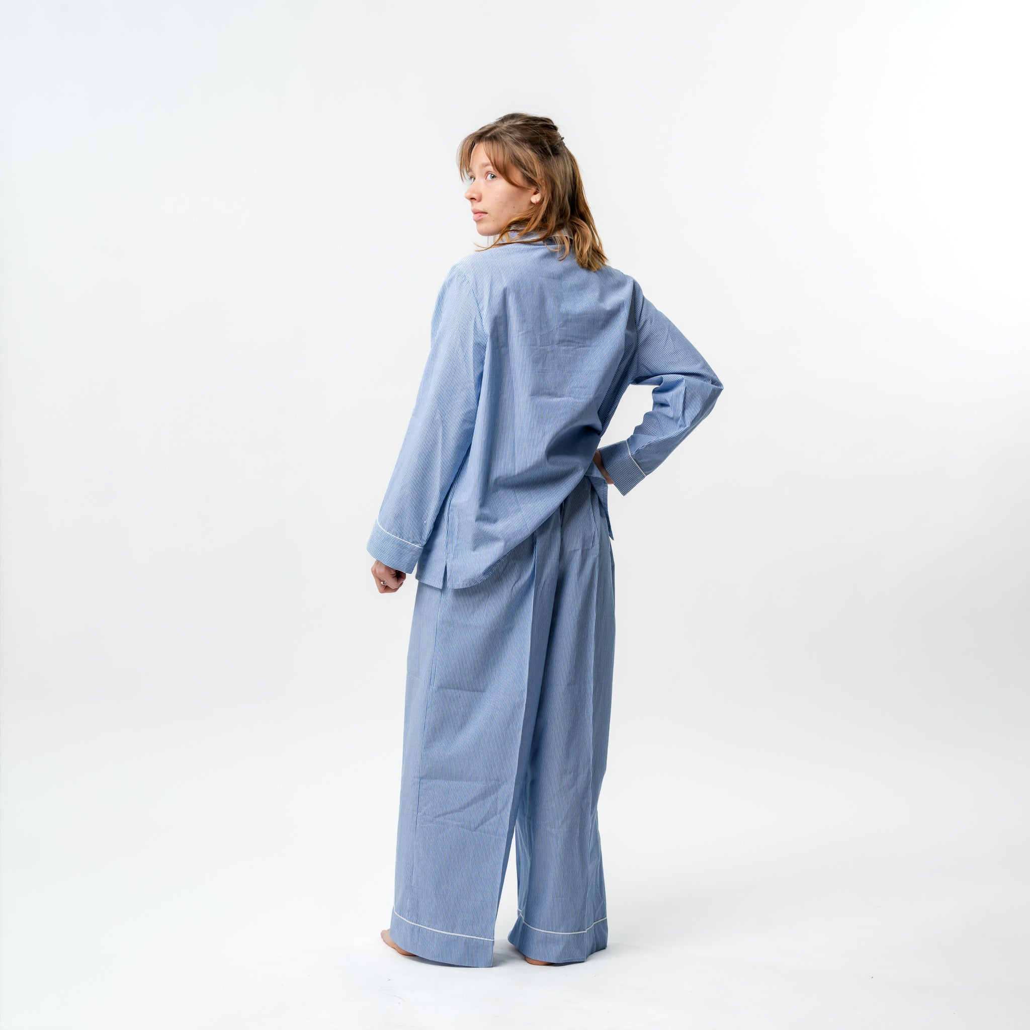 Person wearing a blue checkered outfit on a white background