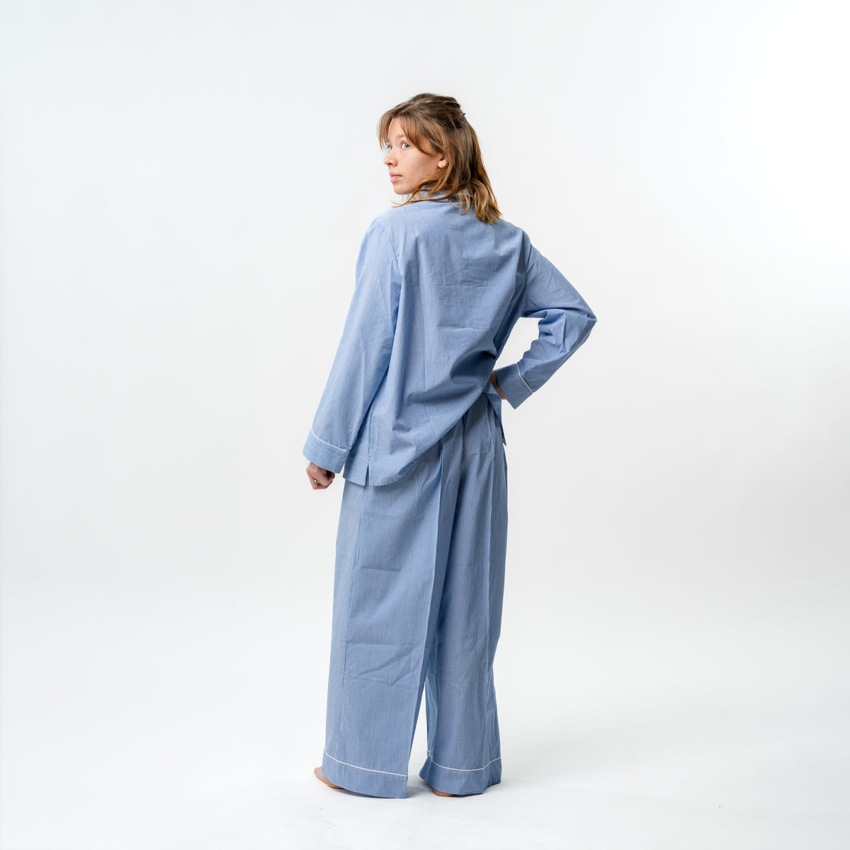 Person wearing a blue checkered outfit on a white background