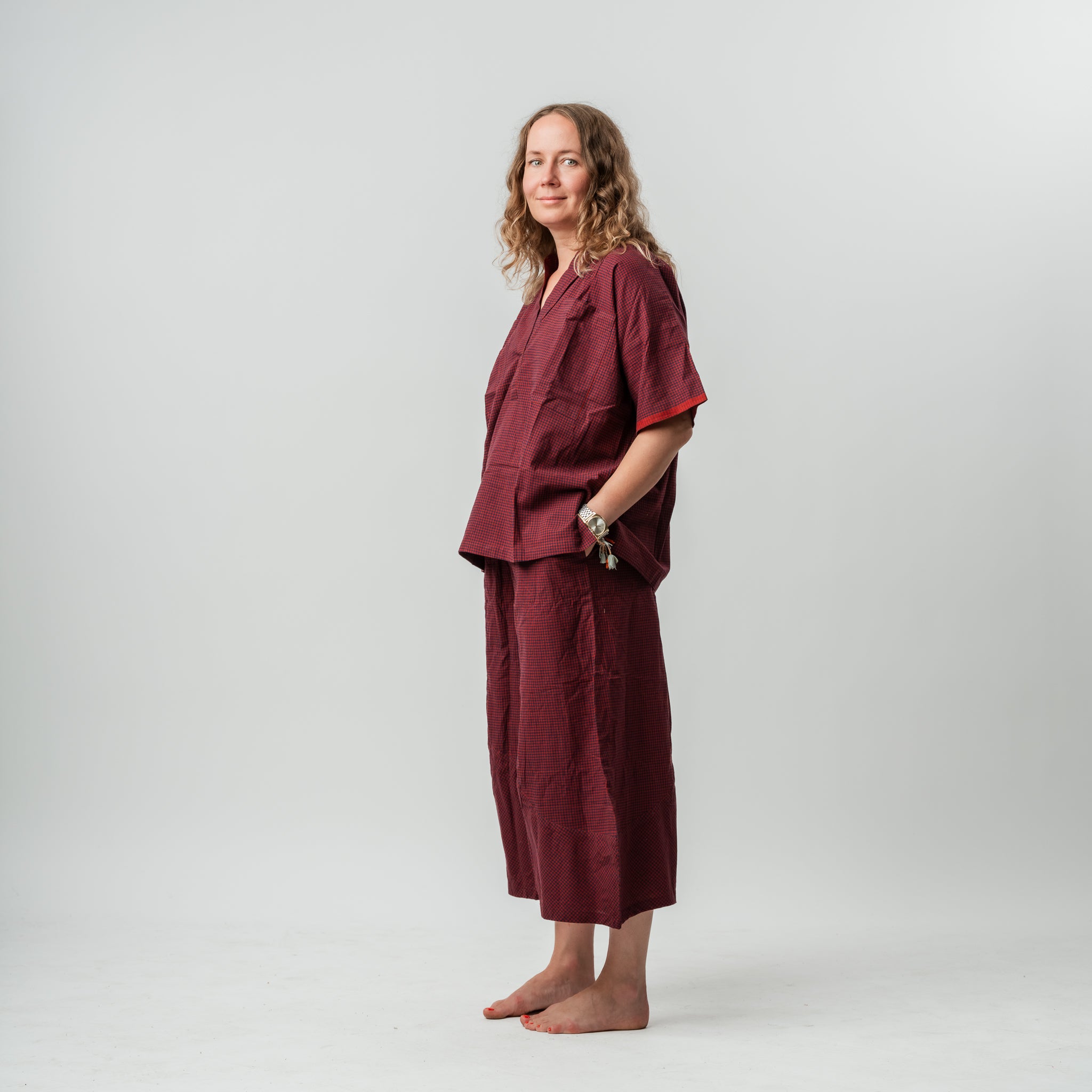 Woman wearing a burgundy outfit against a plain background