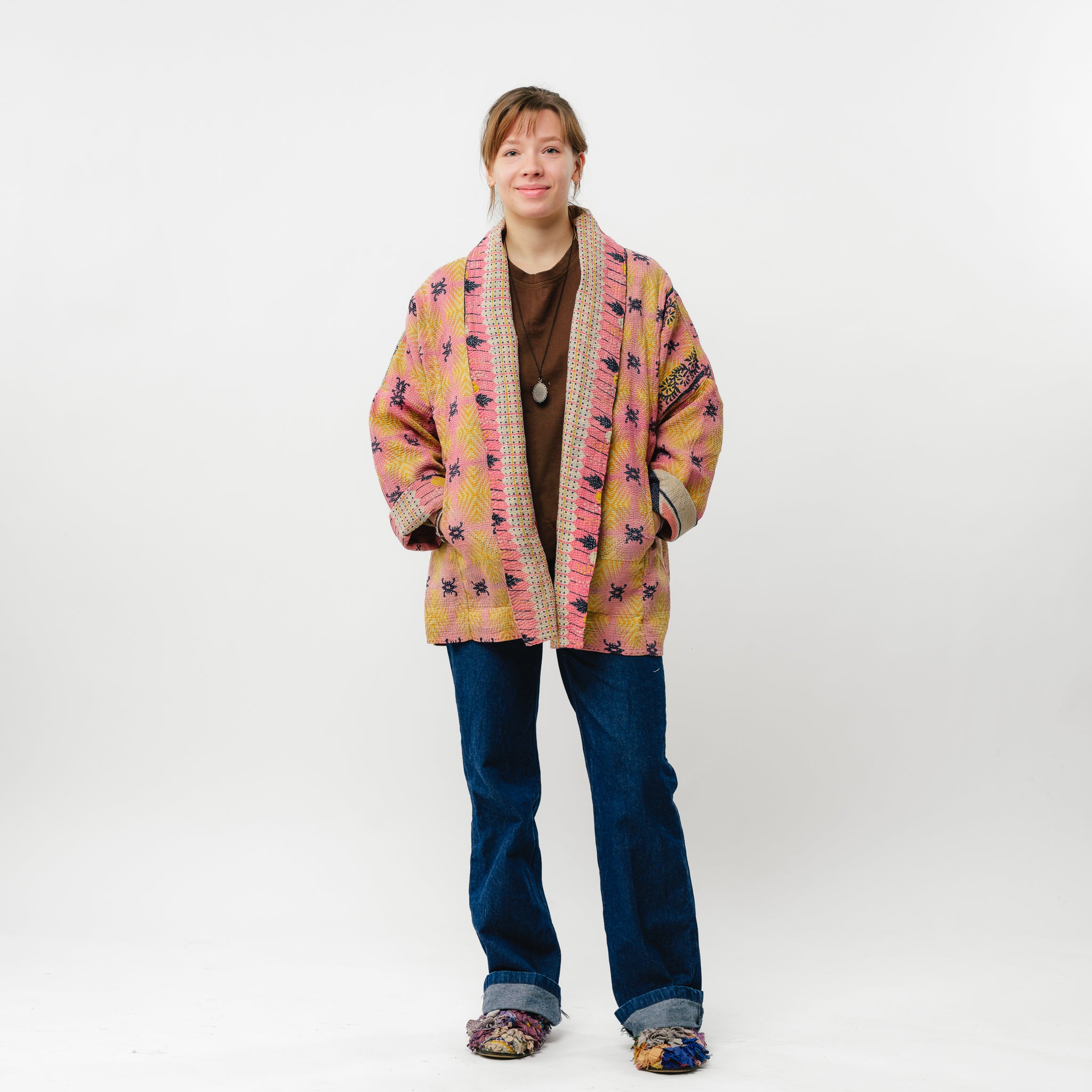 Person wearing a colorful patterned jacket on a white background
