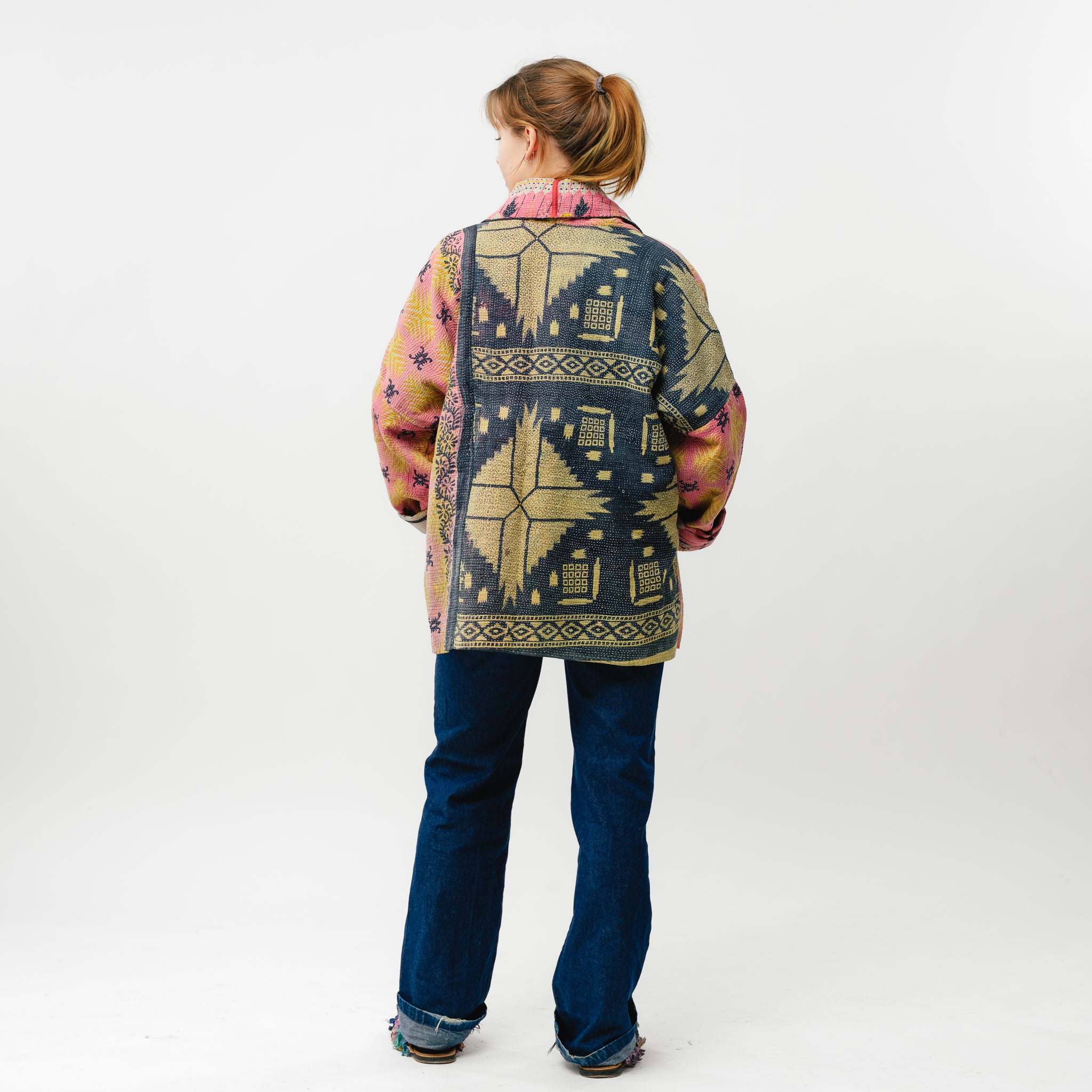 Person wearing a patterned jacket with a white background