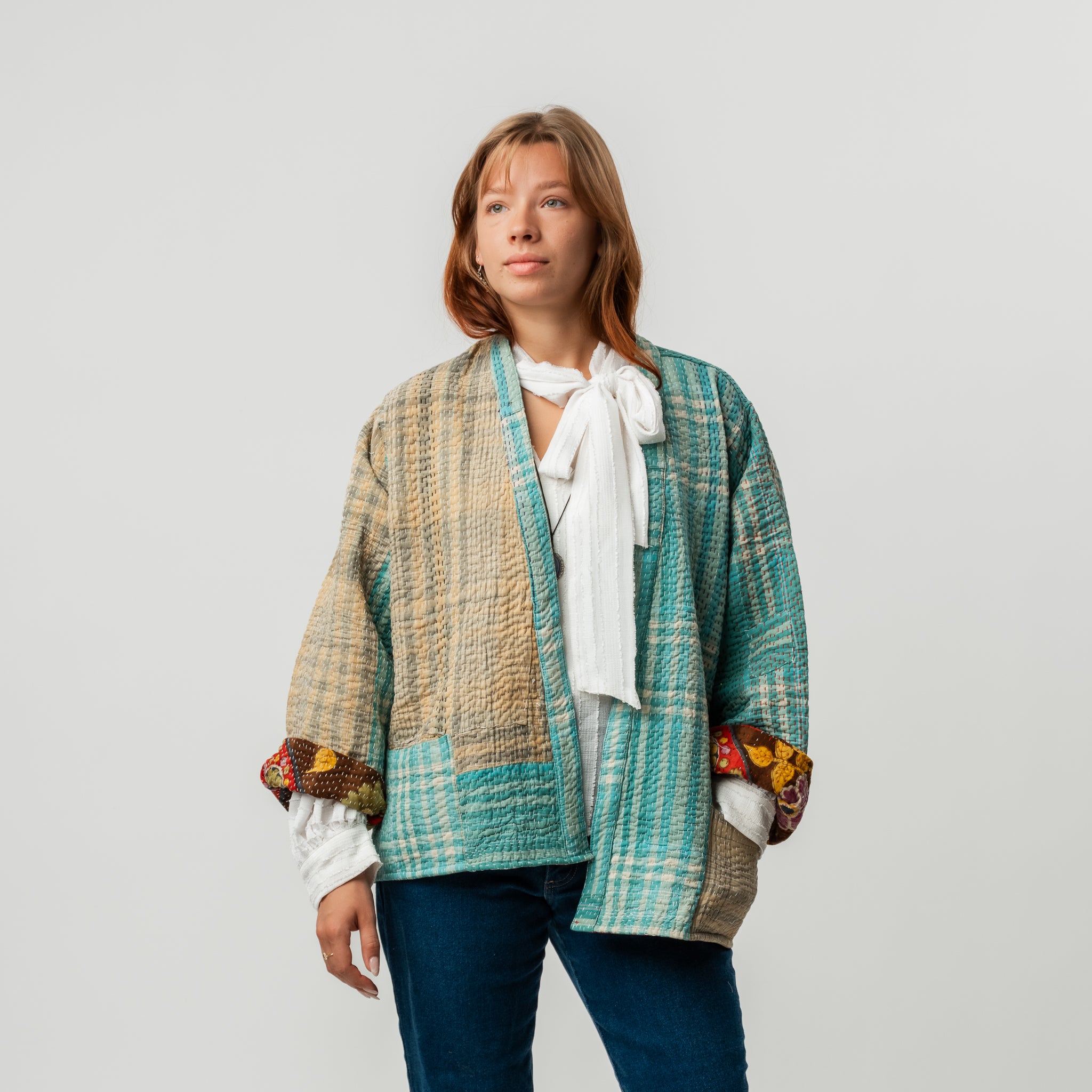Woman wearing a colorful patterned jacket on a plain background