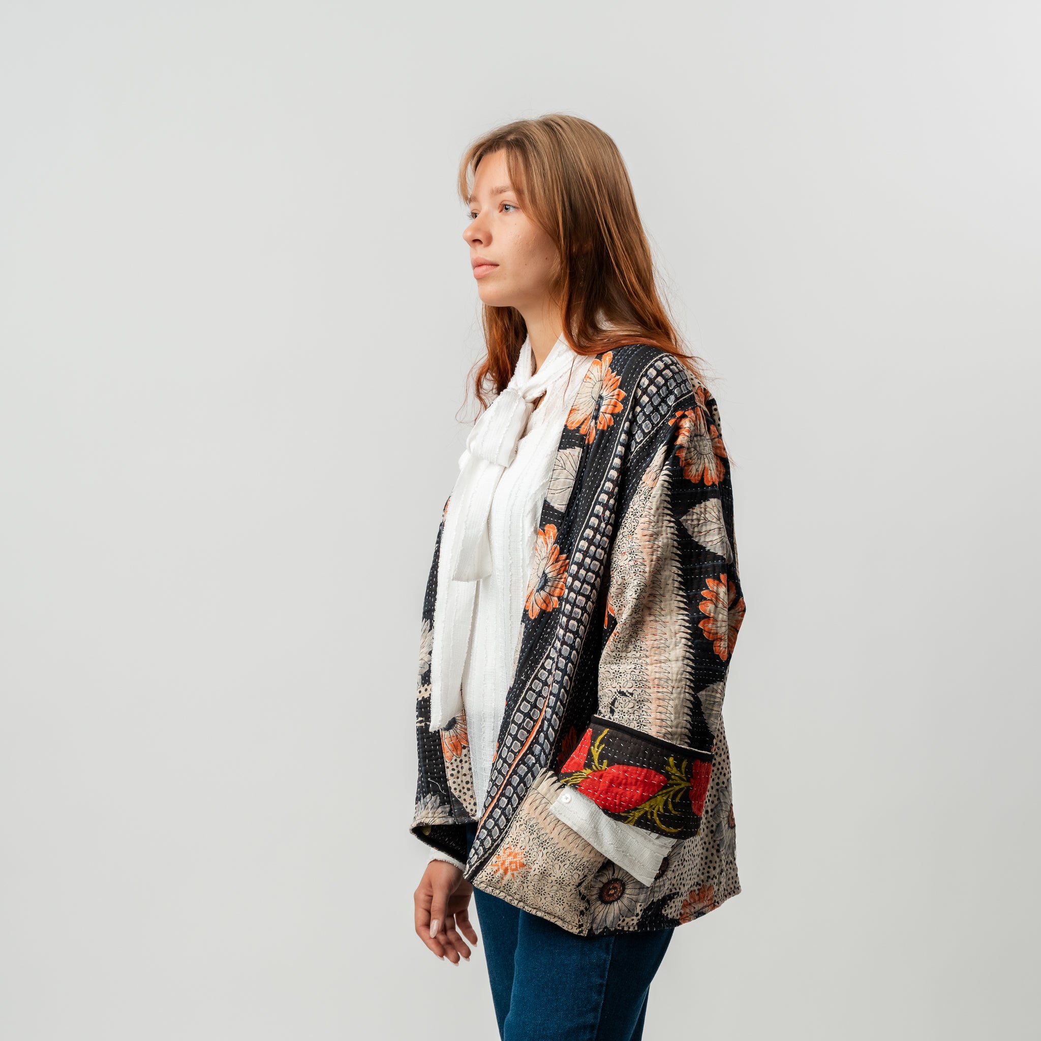 Woman wearing a patterned cardigan on a plain background