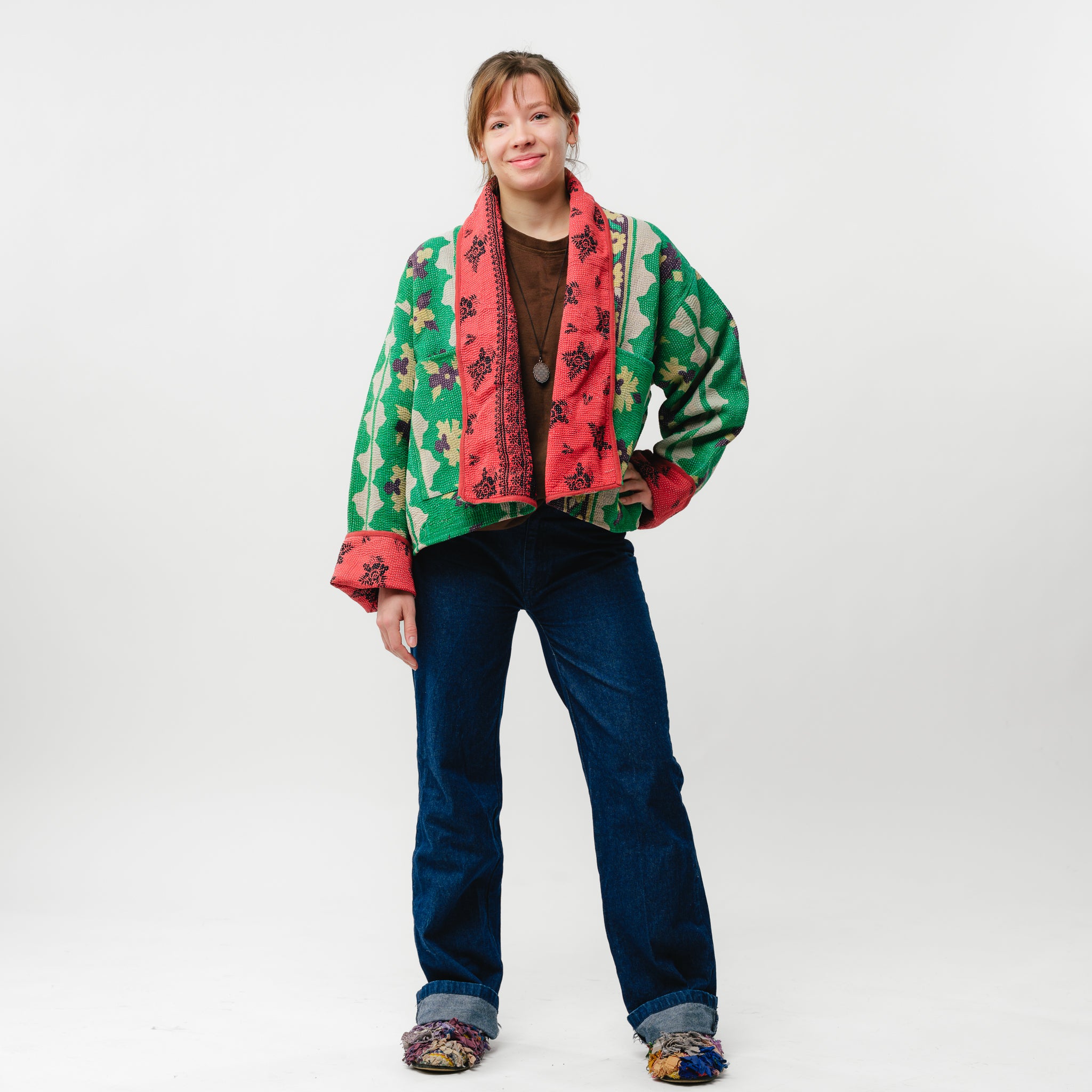 Person wearing a colorful patterned jacket on a white background