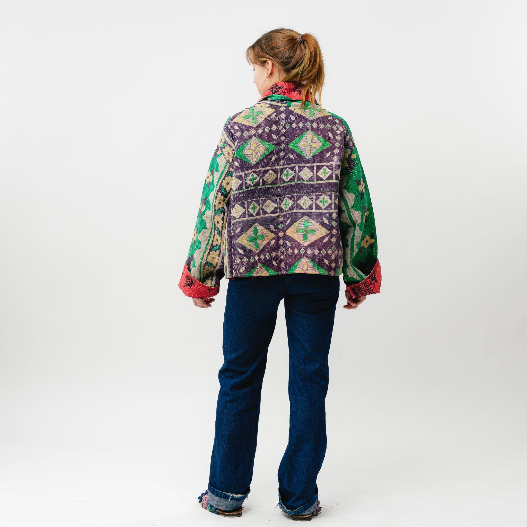 Person wearing a colorful patterned jacket on a white background