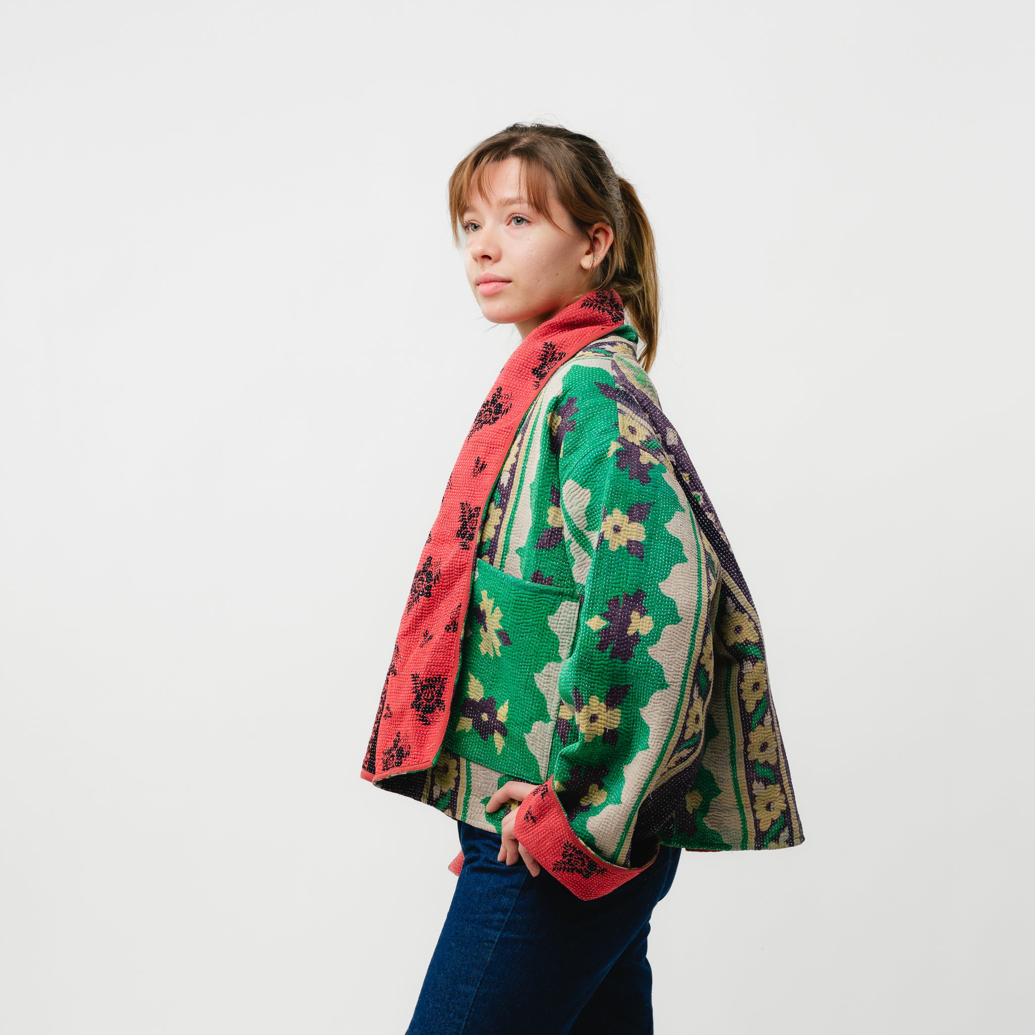 Woman wearing a colorful patterned jacket on a white background