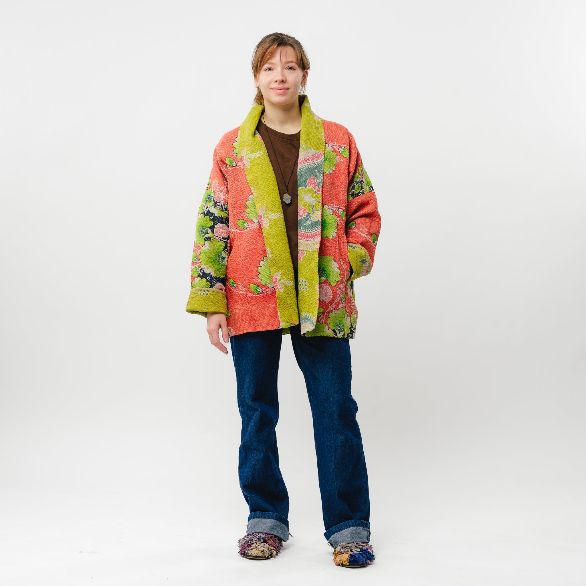 Person wearing a colorful floral jacket on a white background
