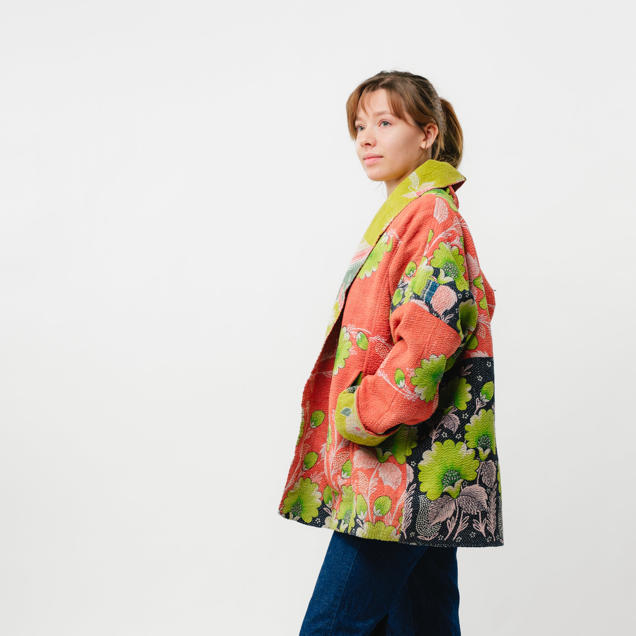 Person wearing a colorful floral jacket on a white background