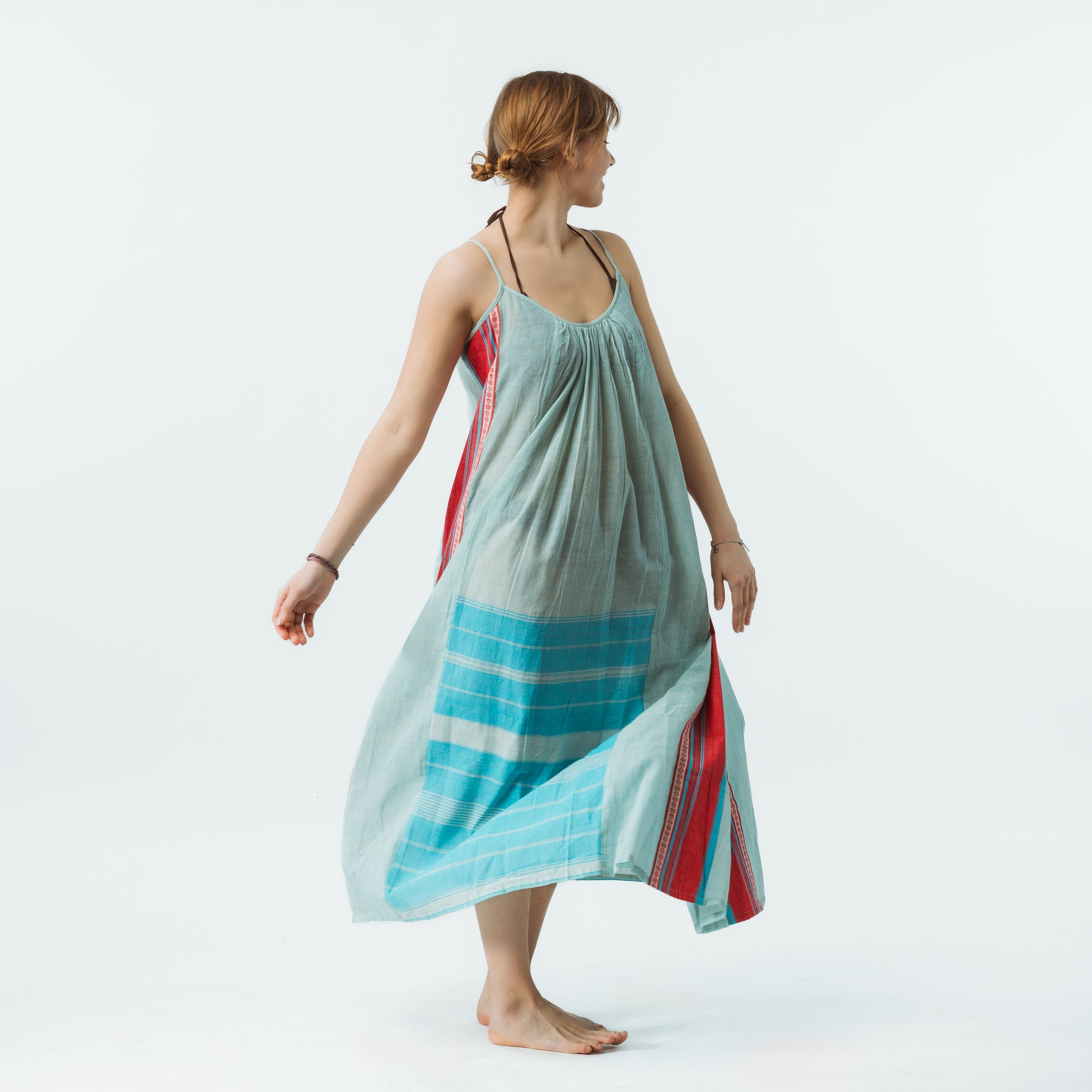Woman wearing a light blue dress with red and blue patterns on a white background