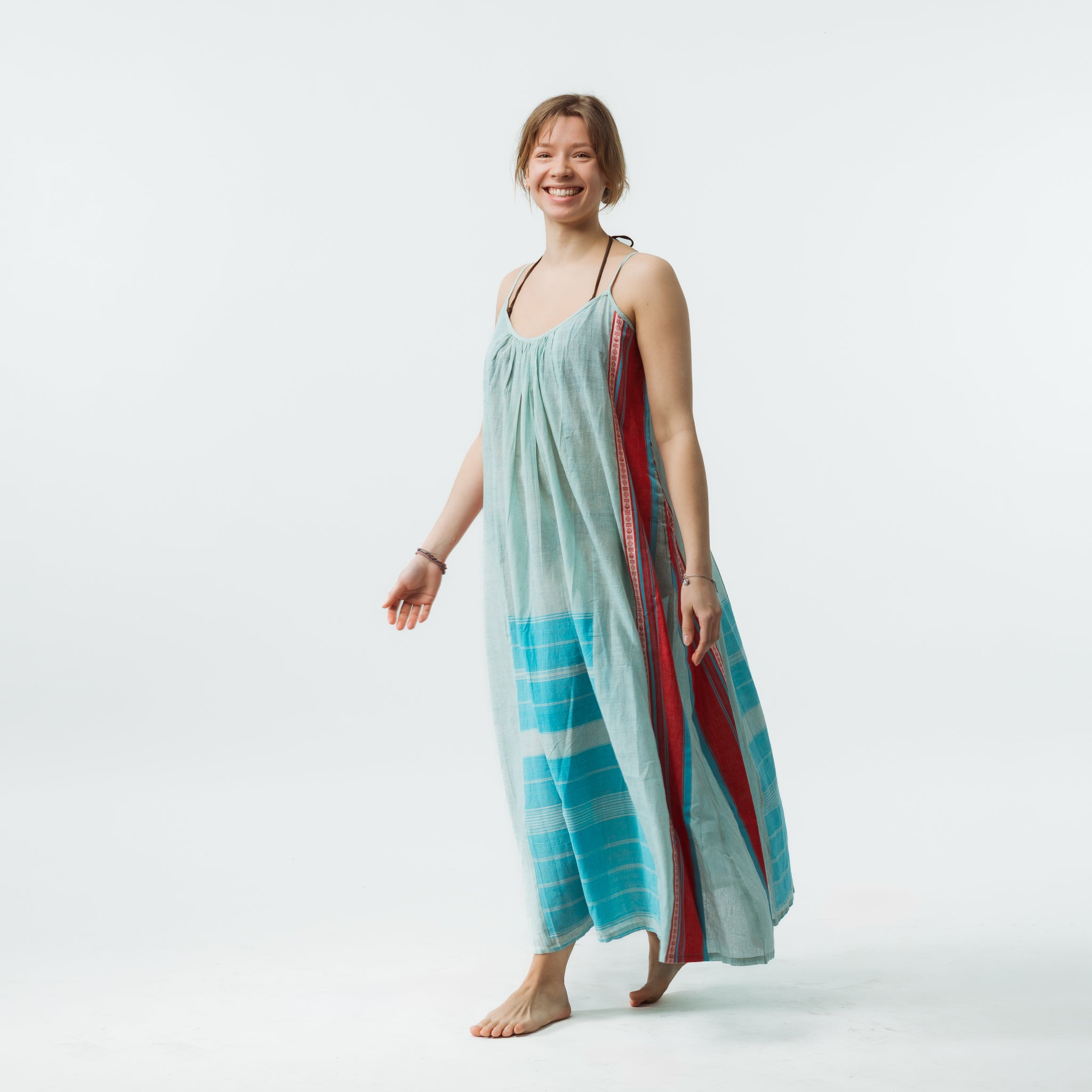 Woman holding a long, colorful dress against a white background