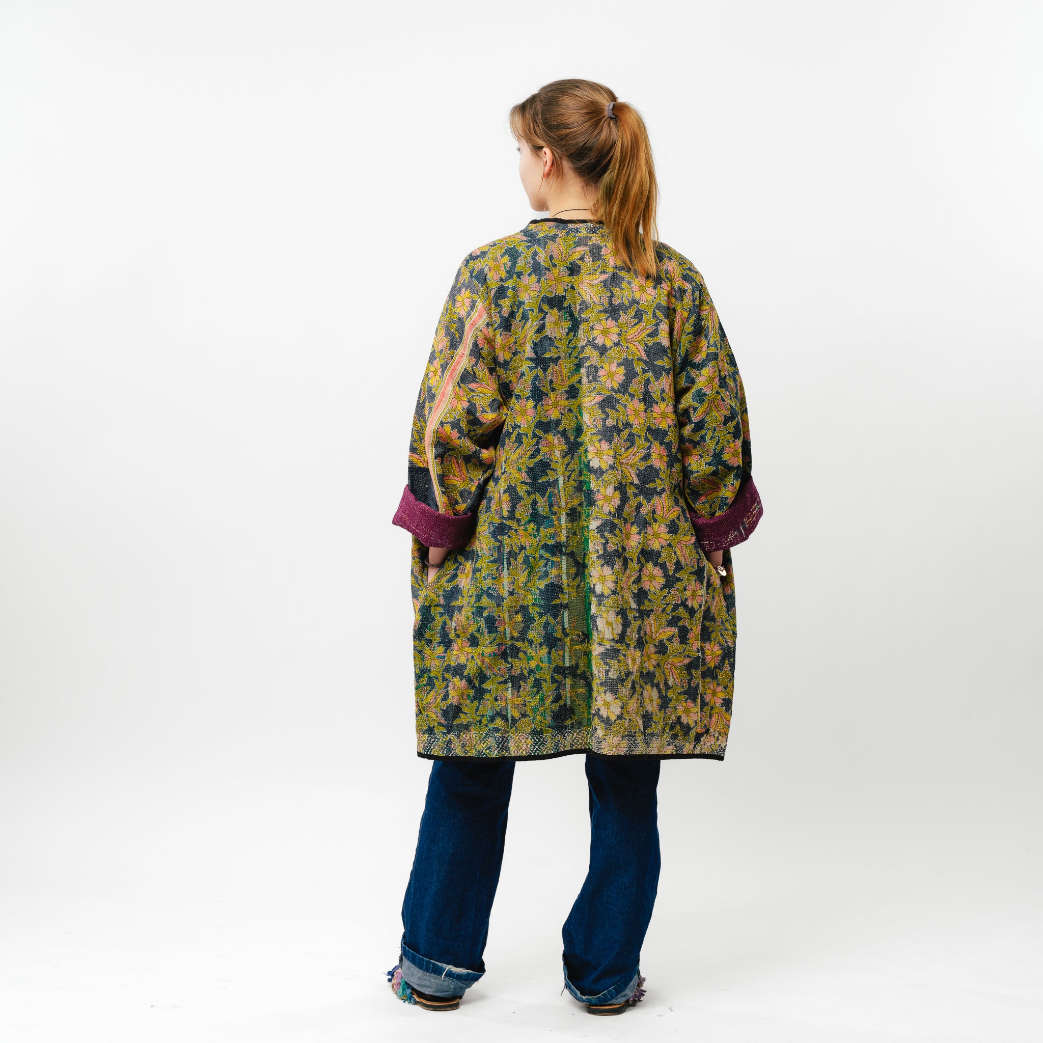 Person wearing a floral patterned coat on a white background