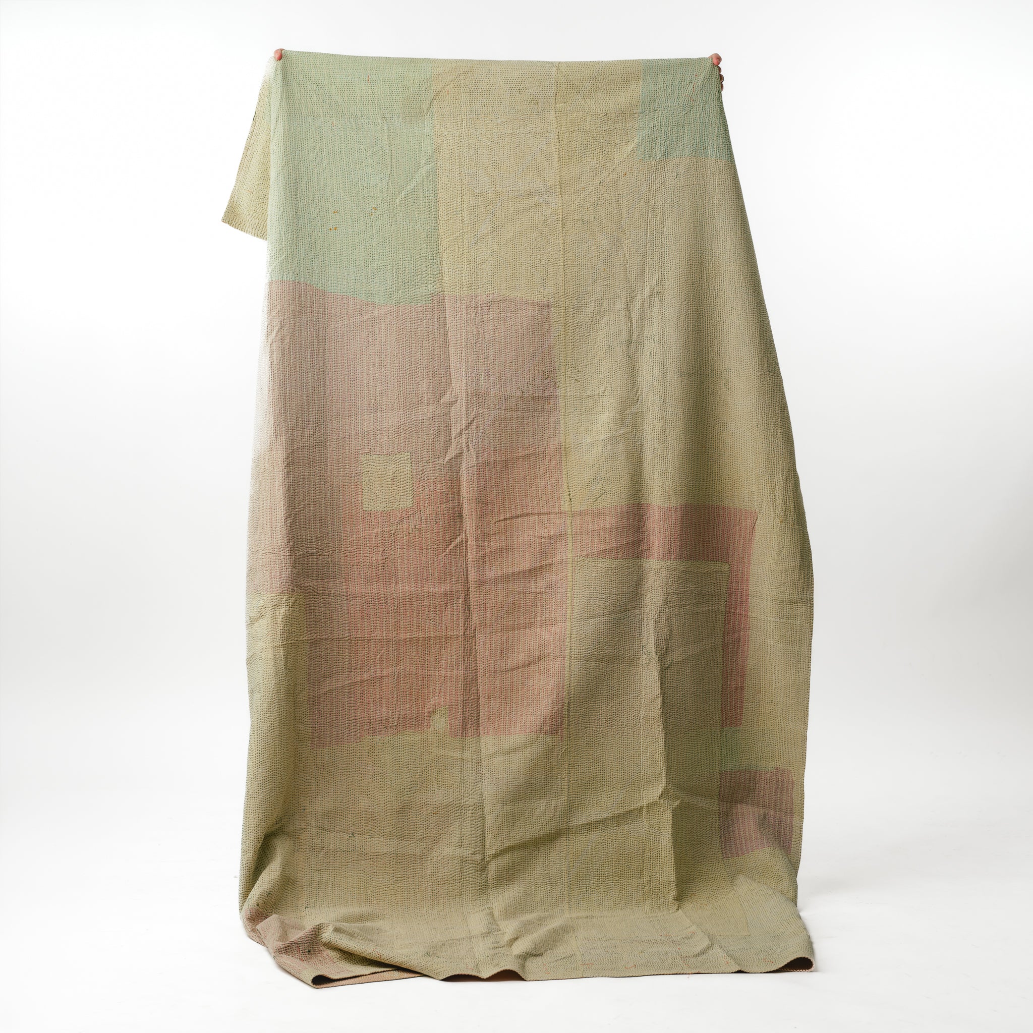 Green and brown patterned fabric draped over a white background