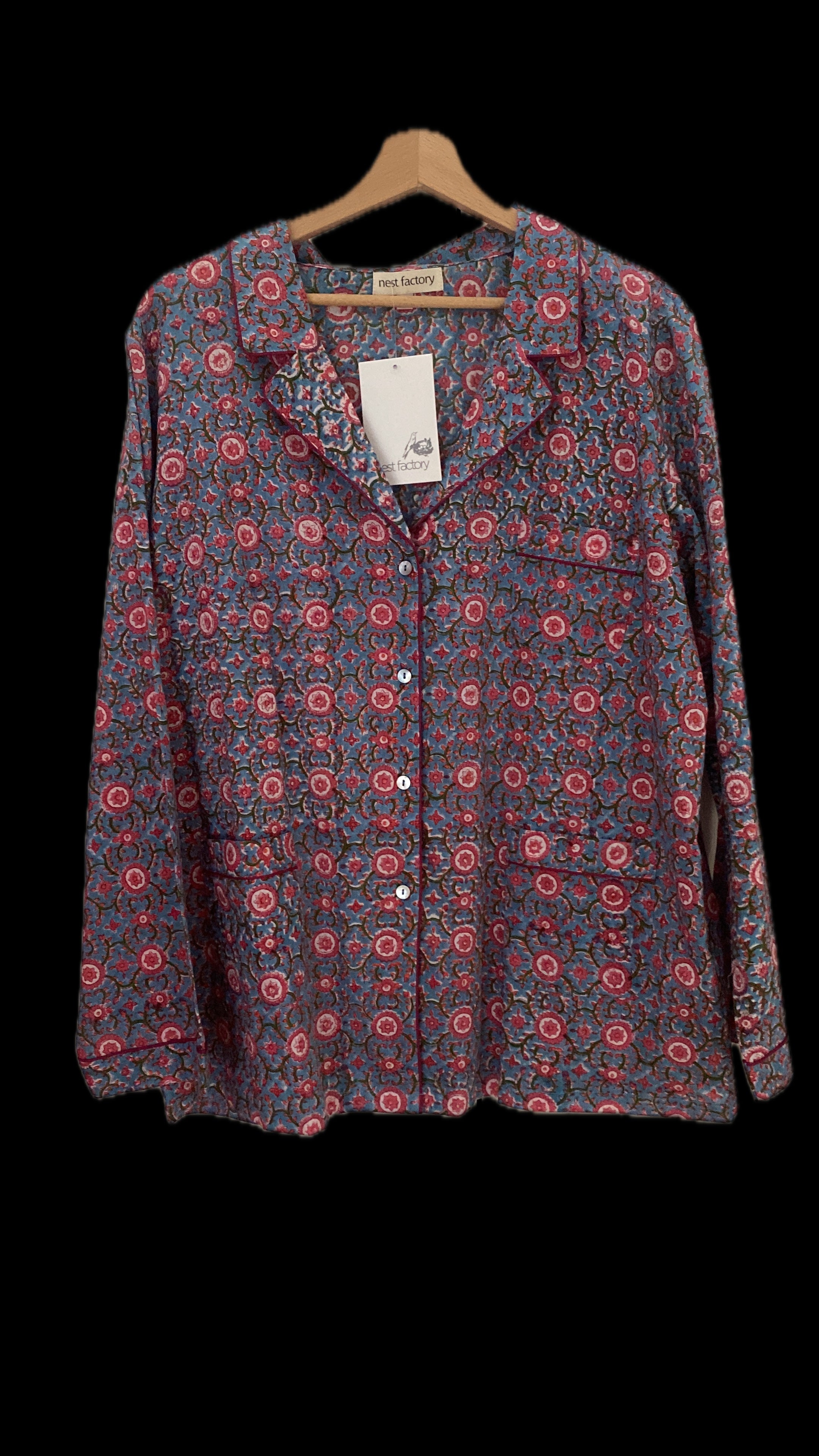 Floral patterned shirt on a hanger with a black background