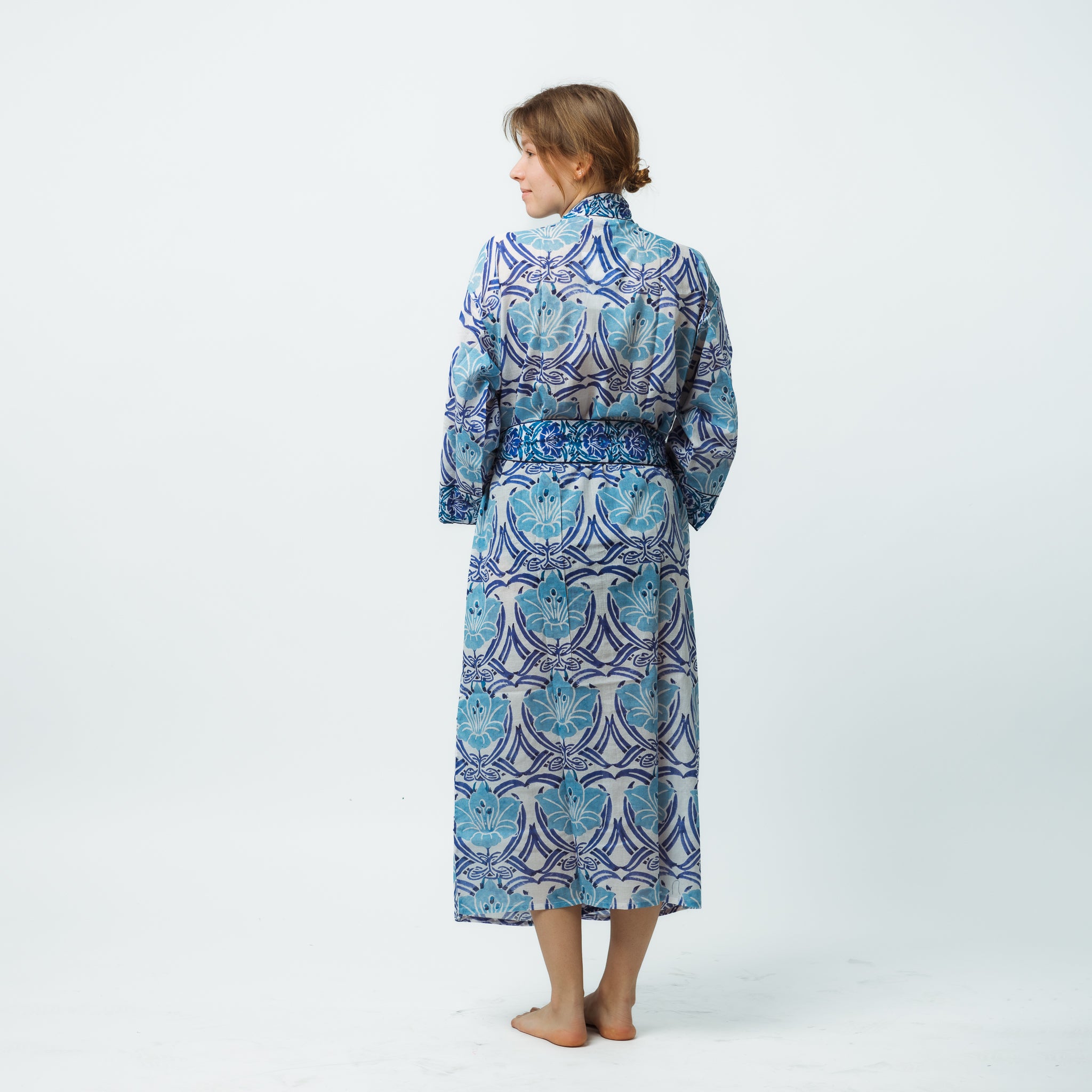 Woman wearing a blue patterned robe on a white background