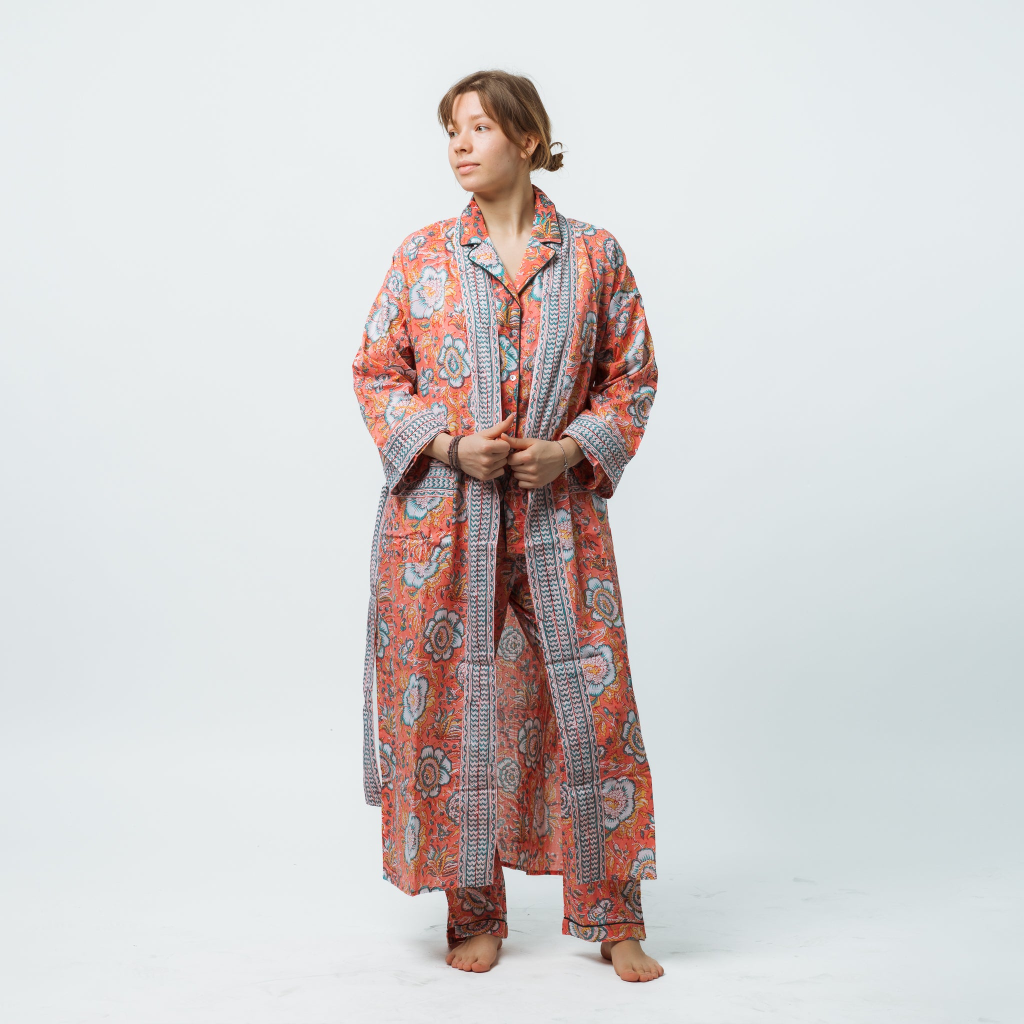 Person wearing a long, patterned robe on a white background