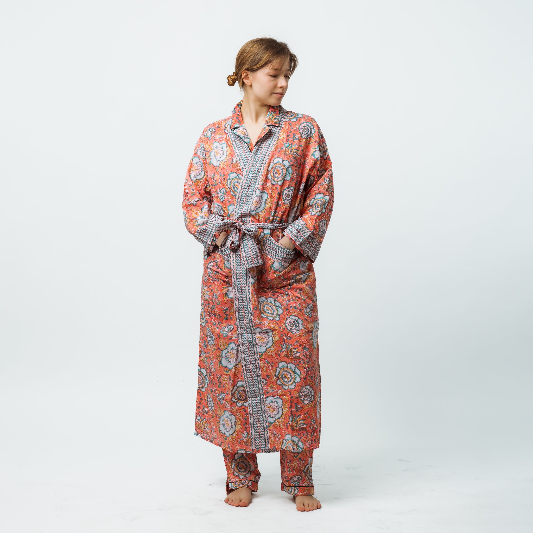 Person wearing a patterned robe and pajama set on a white background