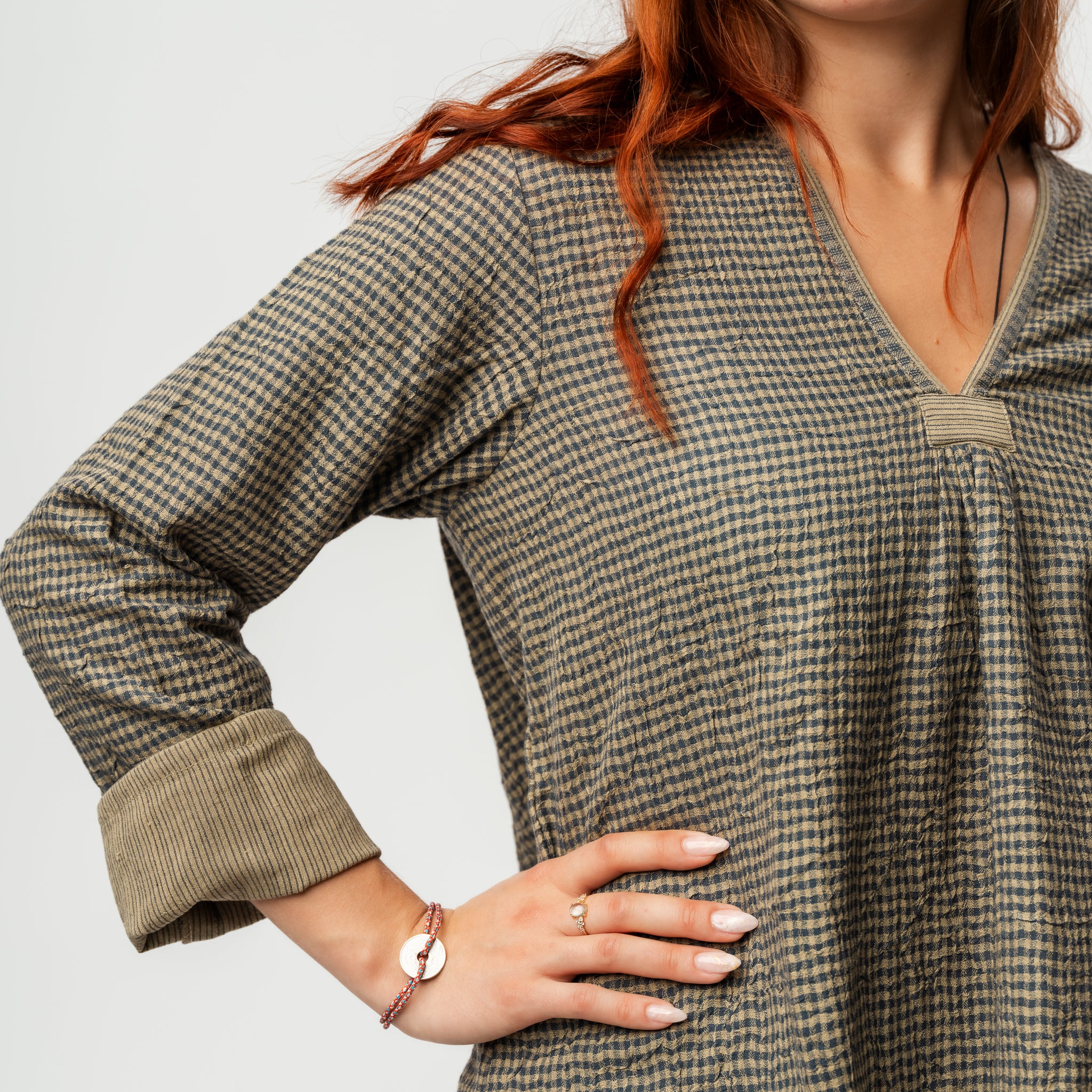 Woman wearing a green checkered dress with a plain background