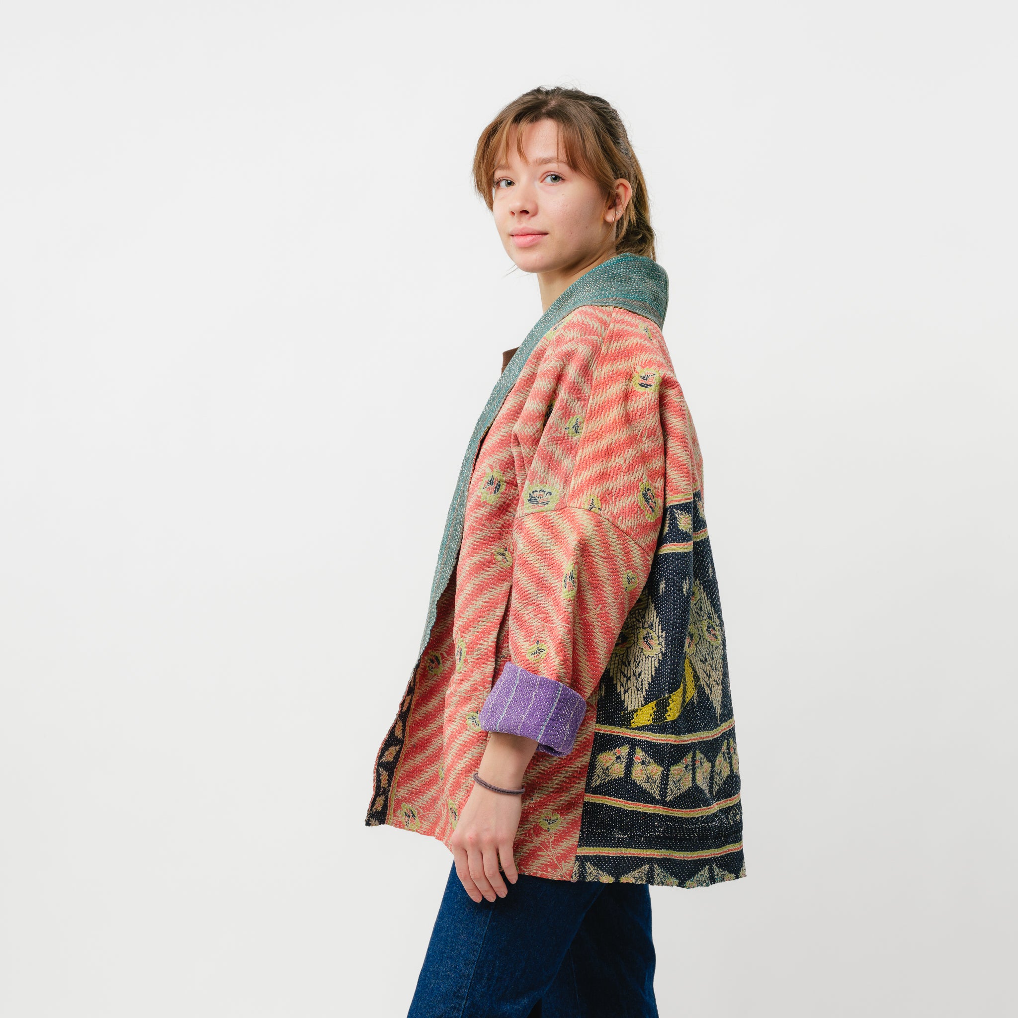 Person wearing a colorful patterned jacket on a white background