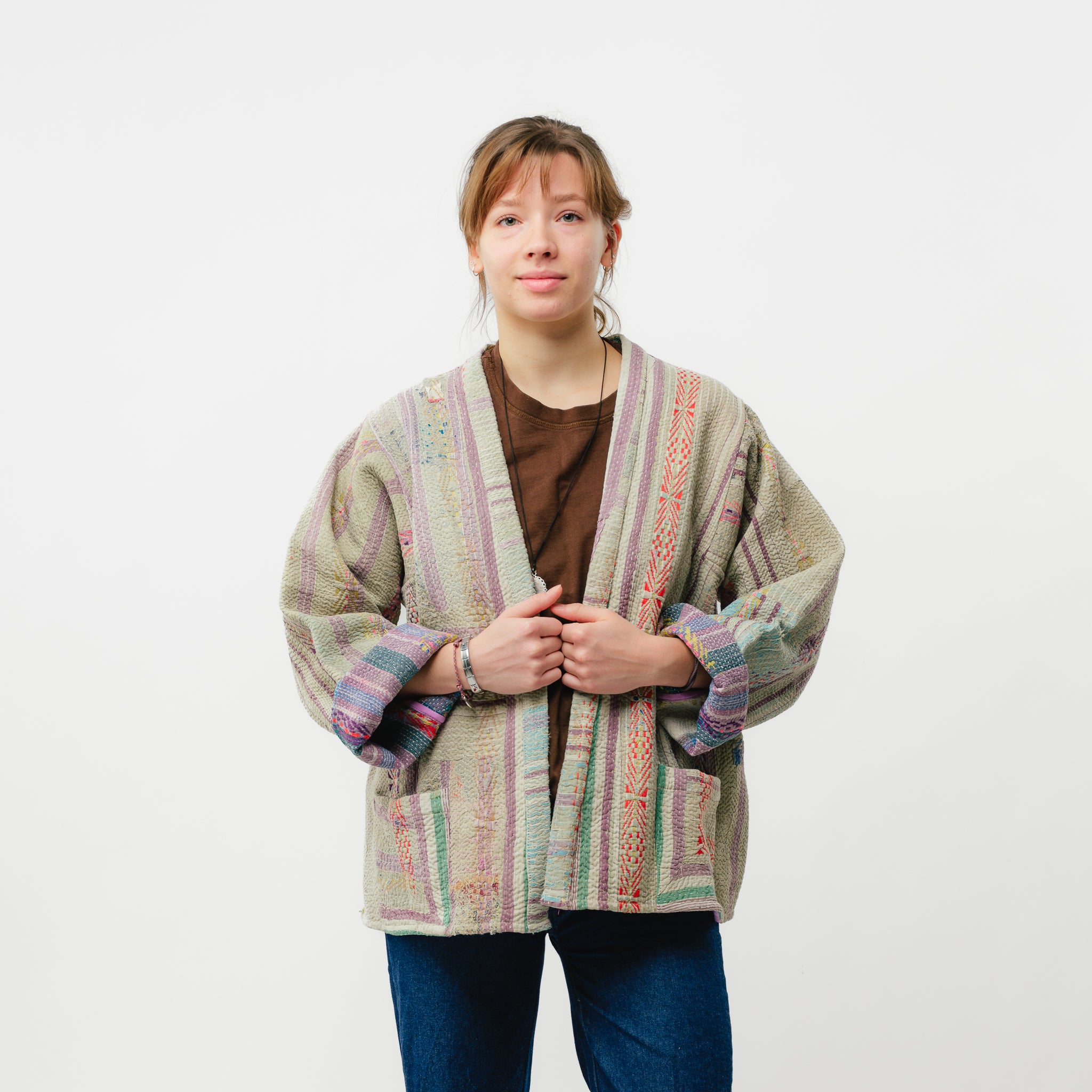 Person wearing a patterned cardigan on a white background