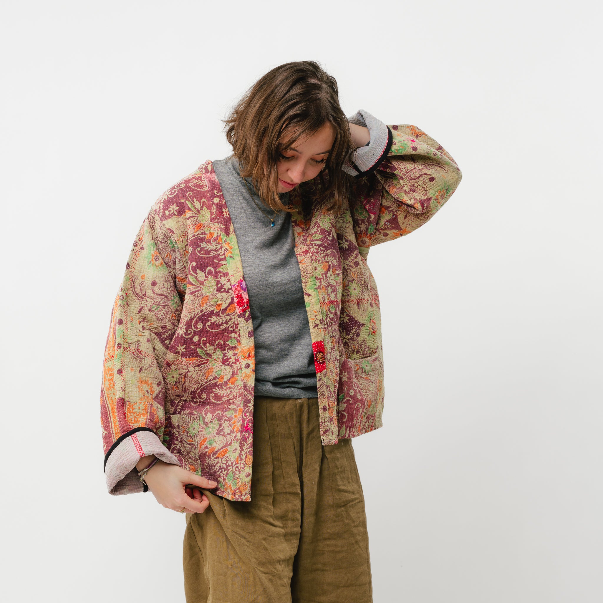 Person wearing a floral quilted jacket on a white background