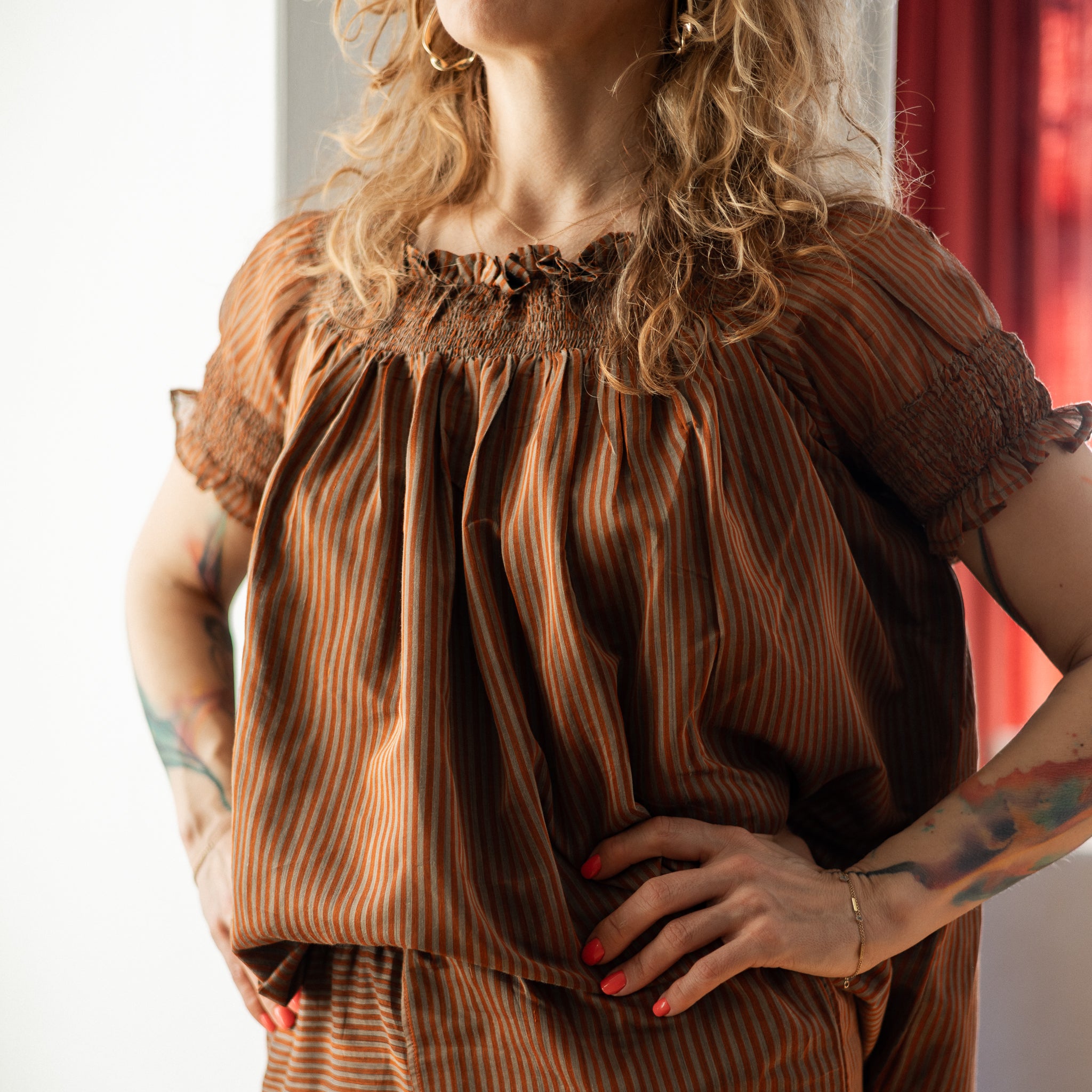 Woman wearing a brown striped blouse with a blurred background