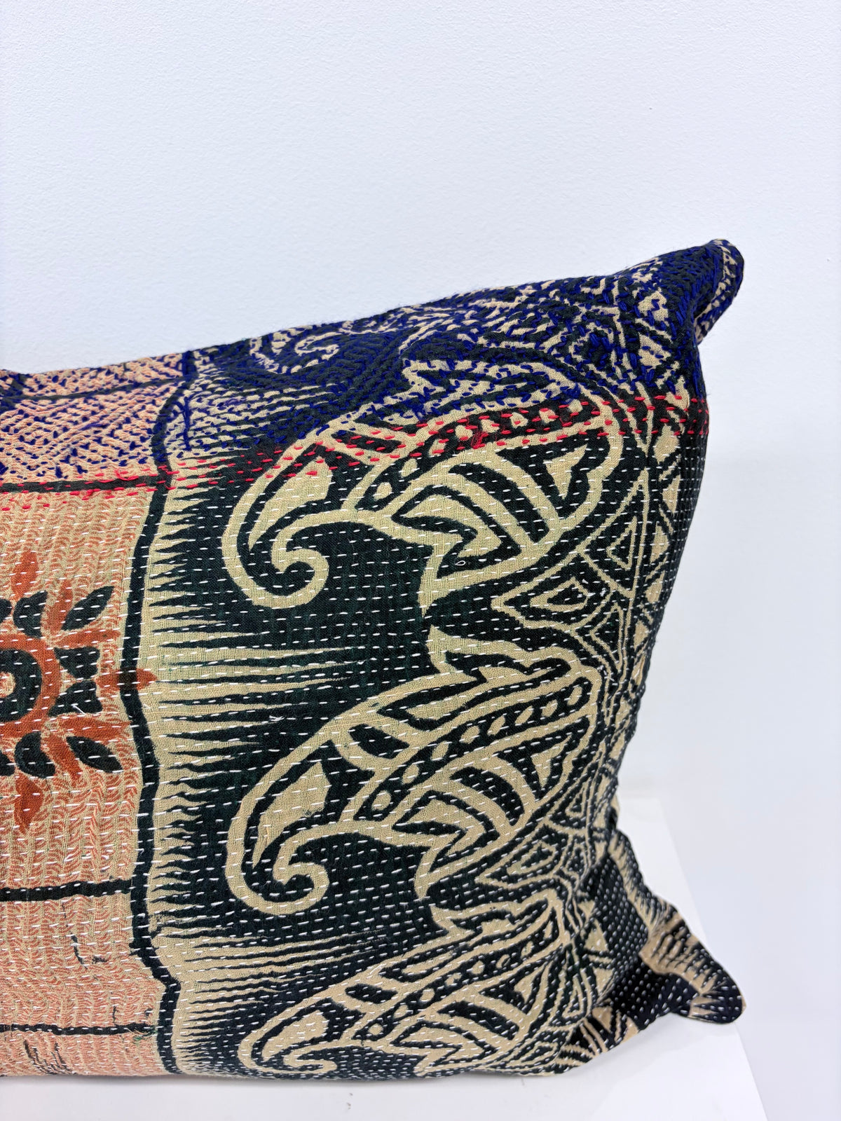 A square decorative throw pillow featuring a detailed, vintage-style woven tapestry pattern in navy blue, beige, and terracotta orange, shown against a plain white background.